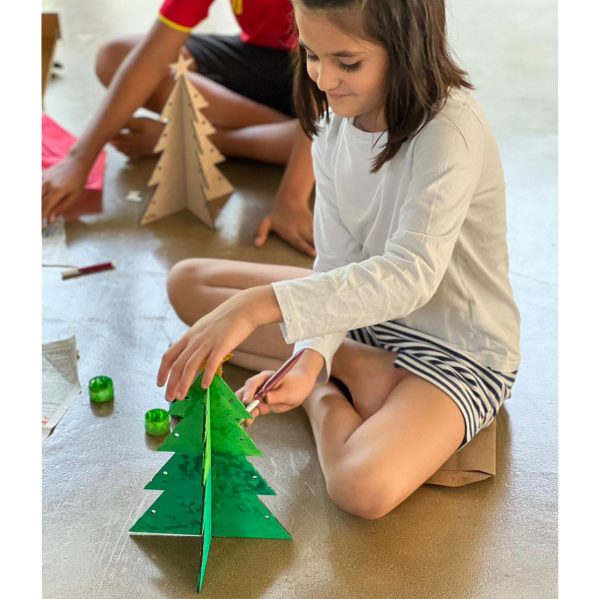 Joyful child artistically painting a homemade Christmas tree, adding a touch of creativity to the festive season